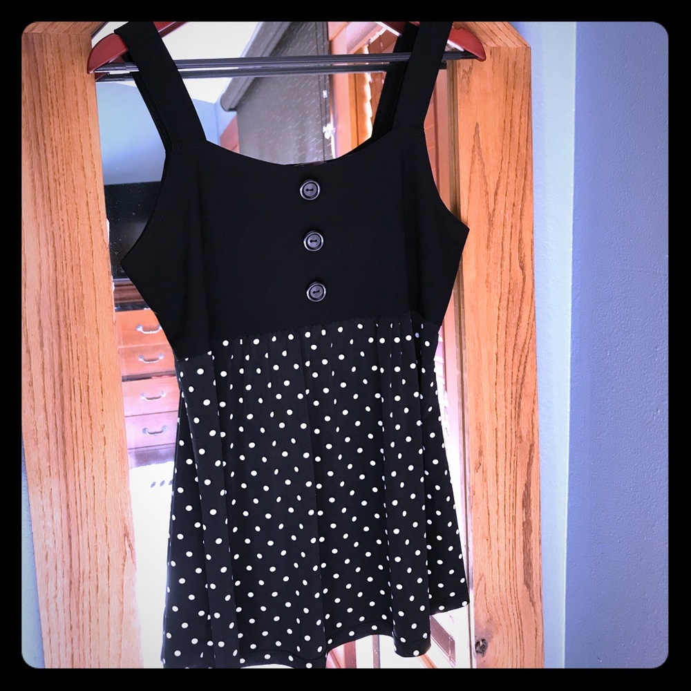 Sleeveless top, black with white polka dots.